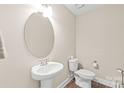 Cozy half-bathroom features a pedestal sink and wood-look flooring at 610 John St, Monroe, NC 28110