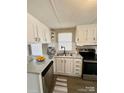 Updated kitchen boasts white cabinetry, stainless steel appliances, and gray countertops at 1718 Fallston Rd, Shelby, NC 28150