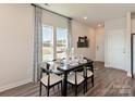 Dining room featuring wood floors, modern lighting, and large windows at 1735 Braemar Village Dr, Monroe, NC 28110