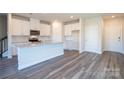 The kitchen boasts an island with granite countertops, white cabinets, and modern fixtures at 1735 Braemar Village Dr, Monroe, NC 28110
