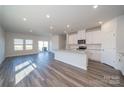 A modern, open-concept kitchen features white cabinets and stainless steel appliances at 1735 Braemar Village Dr, Monroe, NC 28110