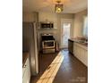 Well-lit kitchen features stainless steel appliances, tile flooring, and a door leading to the backyard at 2220 The Plz, Charlotte, NC 28205