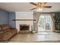 Cozy living room featuring a white-painted brick fireplace and sliding glass doors to the backyard at 227 Water Oak Dr, Pineville, NC 28134