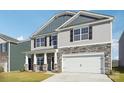 Two-story home featuring gray siding, stone accents, black shutters, and an attached two-car garage at 2323 Riggs Rd, Sherrills Ford, NC 28673