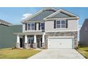 Two-story home featuring gray siding, stone accents, black shutters, and an attached two-car garage at 2323 Riggs Rd, Sherrills Ford, NC 28673