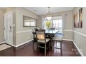 A well-lit dining room with a window, wooden table with chairs, hardwood floors, and neutral wall color at 3516 Mill Stream Ct, Charlotte, NC 28209