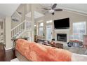 Cozy living room features a fireplace, high ceilings, a ceiling fan, and lots of natural light at 3516 Mill Stream Ct, Charlotte, NC 28209