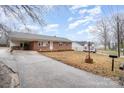 A brick home with a long driveway that is located in a quiet neighborhood with mature trees at 504 Oliver St, Gastonia, NC 28052