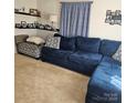 Comfortable living room featuring a large blue sofa, patterned pillows, and decorative shelving at 5516 Northwood Dr, Hickory, NC 28601