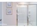 White tiled stand-up shower featuring built-in shelves and a glass door at 7925 Old Brook Rd, Sherrills Ford, NC 28673