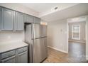 Kitchen featuring gray cabinets and stainless steel refrigerator near a doorway to another room at 8137 Sheringham Way, Charlotte, NC 28227