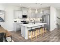 Modern kitchen with stainless steel appliances, gray cabinets, a center island with seating and stylish pendant lighting at 9020 Northfield Crossing Dr, Charlotte, NC 28269