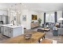 Bright and open living area featuring an island with stools, sleek furniture and modern decor, connecting kitchen to living room at 9020 Northfield Crossing Dr, Charlotte, NC 28269