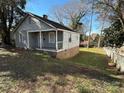 View of the side and front of an older home with a brick foundation and a small front porch at 909 Gibbons St, Gastonia, NC 28052