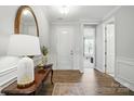 Elegant entryway featuring hardwood floors, decorative table, and mirror creating a warm welcome at 108 Hillston Ln, Mooresville, NC 28115