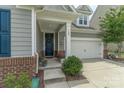 Inviting front porch with a dark front door, brick accents, and a white two-car garage at 108 Hillston Ln, Mooresville, NC 28115
