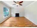 Bright living room featuring hardwood floors, a fireplace, and large windows with natural light at 12025 Willingdon Rd, Huntersville, NC 28078