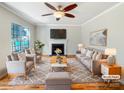 Bright living room featuring hardwood floors, a fireplace, and large windows with natural light at 12025 Willingdon Rd, Huntersville, NC 28078