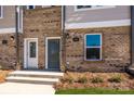 Close up of a townhome entryway with brick, steps, and door at 1311 Cerium Way, Charlotte, NC 28211