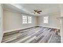 A bright, empty room with hardwood floors, ceiling fan, large windows and modern trim, ready for personalization at 2478 Stribling Cir, Lancaster, SC 29720