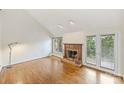 Bright living room with hardwood floors, a charming brick fireplace, and French doors for natural light and access at 309 Settlers Ln, Charlotte, NC 28202