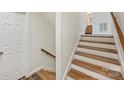 Bright staircase with hardwood steps and white risers, complemented by a wood handrail and a nearby closet at 309 Settlers Ln, Charlotte, NC 28202