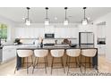 Stylish kitchen with an oversized island with seating, pendant lighting, stainless appliances, and white cabinetry at 680 Candela Ct # 52, York, SC 29745