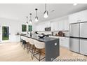 Spacious kitchen with white cabinets, a large island with seating, modern lighting, and stainless steel appliances at 680 Candela Ct # 52, York, SC 29745