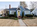 Inviting blue house featuring a well-kept lawn, brick chimney, and bright yellow front door at 968 Waverly Ave, Rock Hill, SC 29730