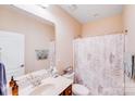 Neutral bathroom with a single vanity, framed mirror and shower with a leafy patterned curtain at 11135 Bailey Park Nature Dr, Cornelius, NC 28031