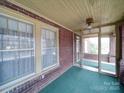 Inviting screened front porch with brick accents and a ceiling fan fixture at 113 2Nd St, Spencer, NC 28159