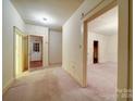 Bright hallway featuring neutral walls, carpet flooring, and multiple doorway entrances at 113 2Nd St, Spencer, NC 28159