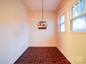 Cozy room featuring red tile floor, vintage light fixture, and bright, natural lighting at 113 2Nd St, Spencer, NC 28159