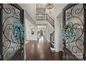 Grand foyer showcasing soaring ceilings, dark hardwood floors, and an elegant staircase with iron railings at 17639 Stuttgart Rd, Davidson, NC 28036