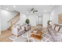 Bright living room with modern furnishings, open staircase, and light hardwood floors at 2809 New Pineola Rd, Charlotte, NC 28208