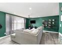 Spacious living room with green walls, a gray couch, a ceiling fan, and ample natural light at 4000 Elizabeth St, Hickory, NC 28601