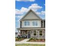 Charming two-story home with stone accents, covered porch, and manicured landscaping creates curb appeal at 4230 Black Ct # 235, Harrisburg, NC 28075