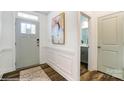 Bright foyer with hardwood floors, wainscoting, and a view into the bathroom at 4230 Black Ct # 235, Harrisburg, NC 28075