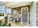 Inviting front porch featuring stone accents, a seating area, and a stylish front door at 4230 Black Ct # 235, Harrisburg, NC 28075