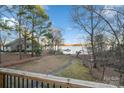 Backyard view from the deck featuring mature trees, lush lawn, lake view, and a boat dock at 5580 Crepe Myrtle Rd, York, SC 29745