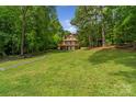 Two story home is nestled in lush greenery, featuring multiple balconies and windows overlooking the expansive lawn at 5580 Crepe Myrtle Rd, York, SC 29745