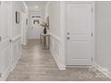 Bright hallway featuring classic molding details, light wood flooring, and an inviting entryway with a glimpse of the front door at 108 Sari St, Troutman, NC 28166