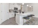 Stylish kitchen featuring a center island with seating, modern stainless steel appliances, and sleek white cabinetry at 108 Sari St, Troutman, NC 28166