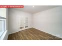 Bright, open living area featuring wood floors, a large window, and french doors at 11123 Cardinal Creek Ave, Charlotte, NC 28215