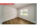 Bright, open living area featuring wood floors, a large window, and french doors at 11123 Cardinal Creek Ave, Charlotte, NC 28215