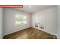 Bright, open living area featuring wood floors, a large window, and french doors at 11123 Cardinal Creek Ave, Charlotte, NC 28215