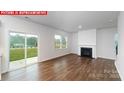 Bright living room with a cozy fireplace, sliding glass door to backyard, and hardwood flooring at 11204 Cardinal Creek Ave, Charlotte, NC 28215