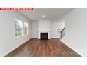 Bright living room with a cozy fireplace, large windows offering natural light, and hardwood flooring at 11204 Cardinal Creek Ave, Charlotte, NC 28215