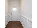 Inviting entryway featuring wood-look floors, white walls and trim, and a front door with glass pane at 119 Noah Ln, Troutman, NC 28166