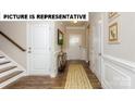 Inviting entryway with hardwood floors, decorative rug, and classic white wainscoting at 121 Noah Ln, Troutman, NC 28166